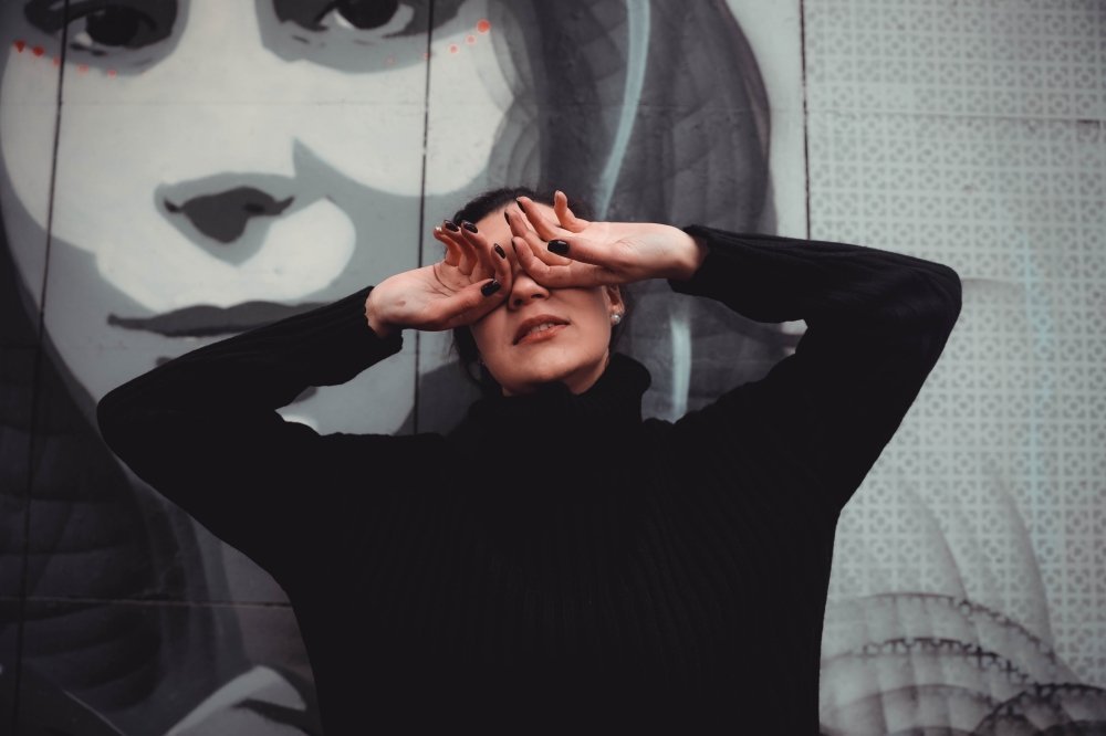 Woman covering her eyes with her hands — when sleep feels unsafe after trauma